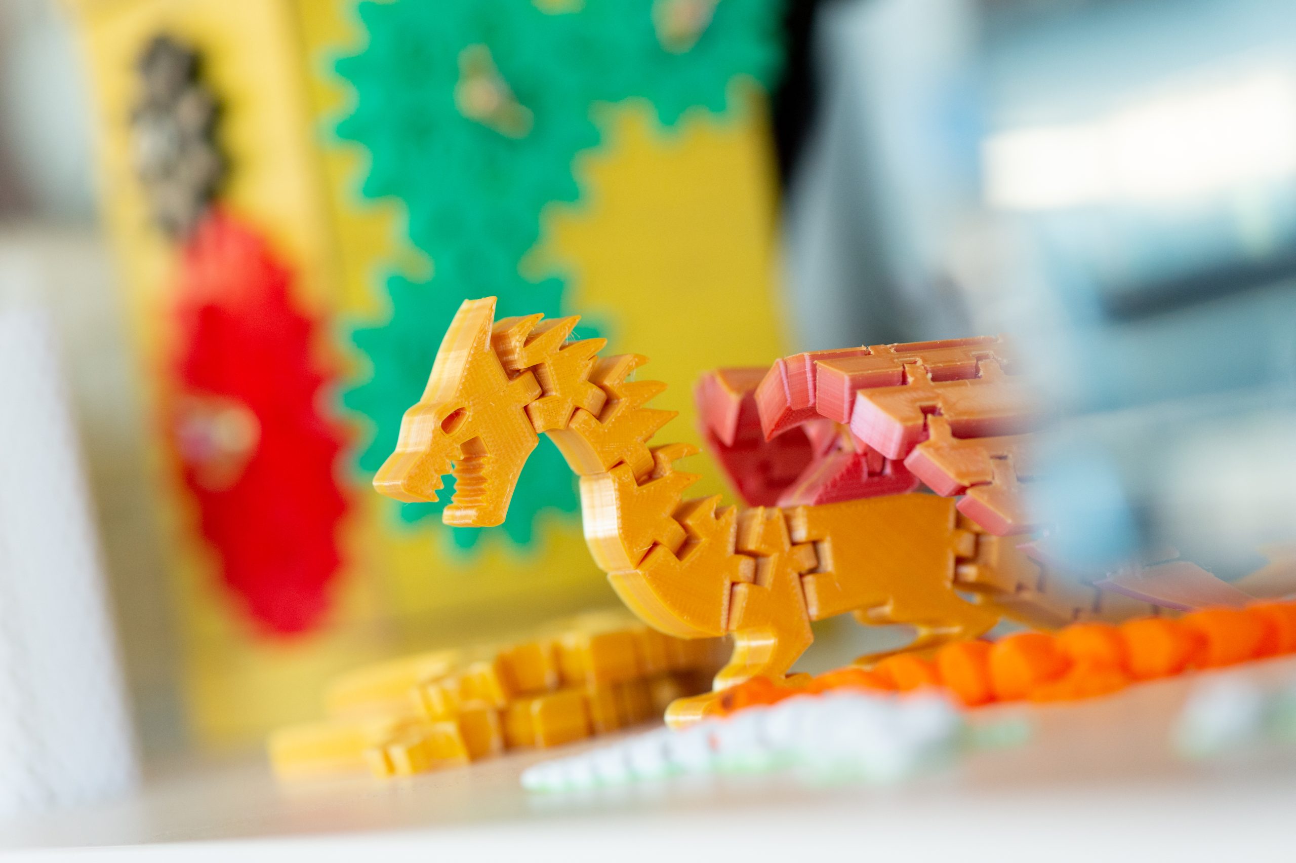 close up of an articulating plastic orange dragon with wings